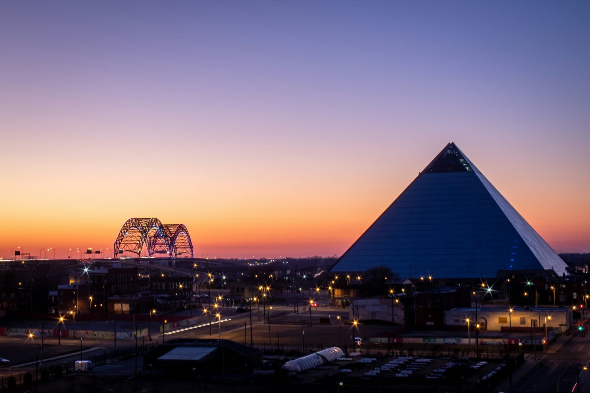 The Memphis skyline and the Hernando de Soto bridge over the Mississippi River at dusk